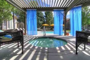A covered outdoor pool area with two wicker chairs and a hot tub. - Peaceful Retreat*Close to SKIING*Hot tub*Gym (Midvale)