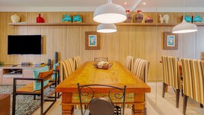 A dining area with a wooden table, striped chairs, and pendant lights.