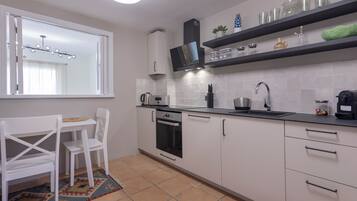 Apartamento | Cocina privada | Frigorífico, microondas, horno y placa de cocina