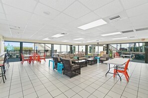 Un espace intérieur vaste et bien aménagé, avec différents types de sièges, notamment des canapés et des fauteuils, ainsi qu’une grande table.