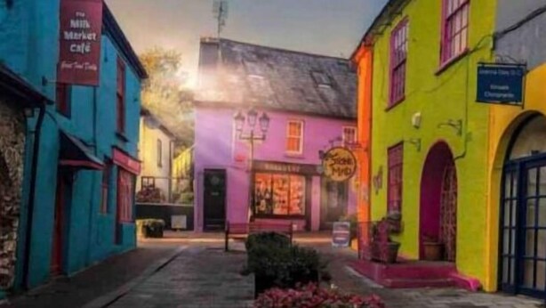 A narrow street with colorful buildings, a red bench, and a small shop with a sign. - 3 min walk in to town , Great location in town (kinsale)