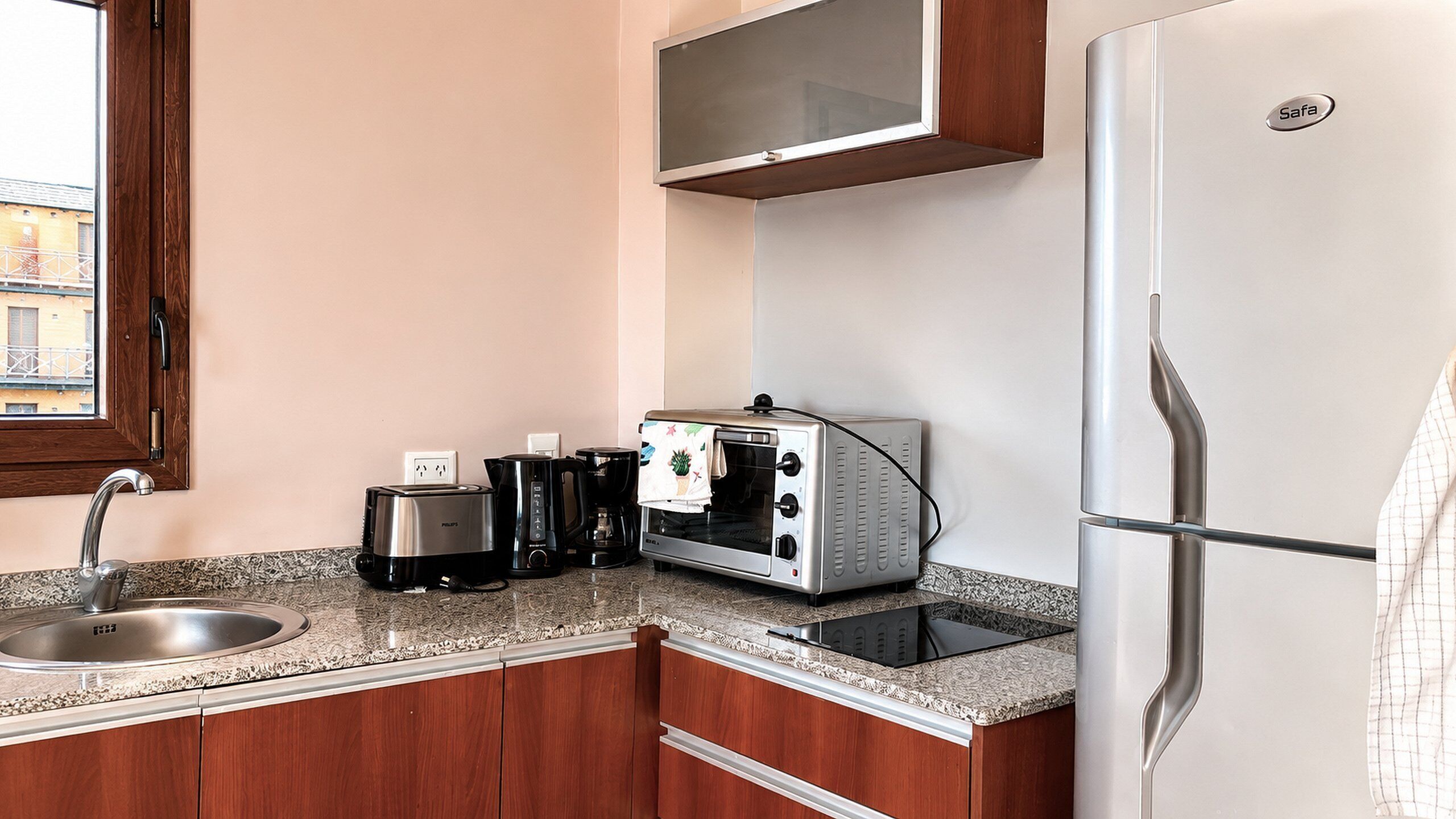 Une petite cuisine équipée d’un évier, d’un grille-pain, d’une machine à café et d’un réfrigérateur.