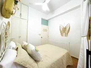 A bedroom with a bed, pillows, a wardrobe, and a butterfly wall decoration. - Primer Nivel Zona Colonial (Santo Domingo)