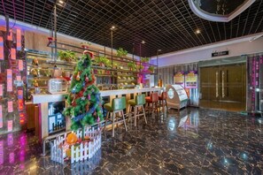 A modern indoor space with a Christmas tree, a reception desk, and a vending machine. - Aifeier Shishang Hotel (Zhengzhou)