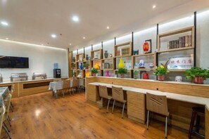 Un área de bar moderna con suelo de madera, taburetes y estanterías con diversos objetos.