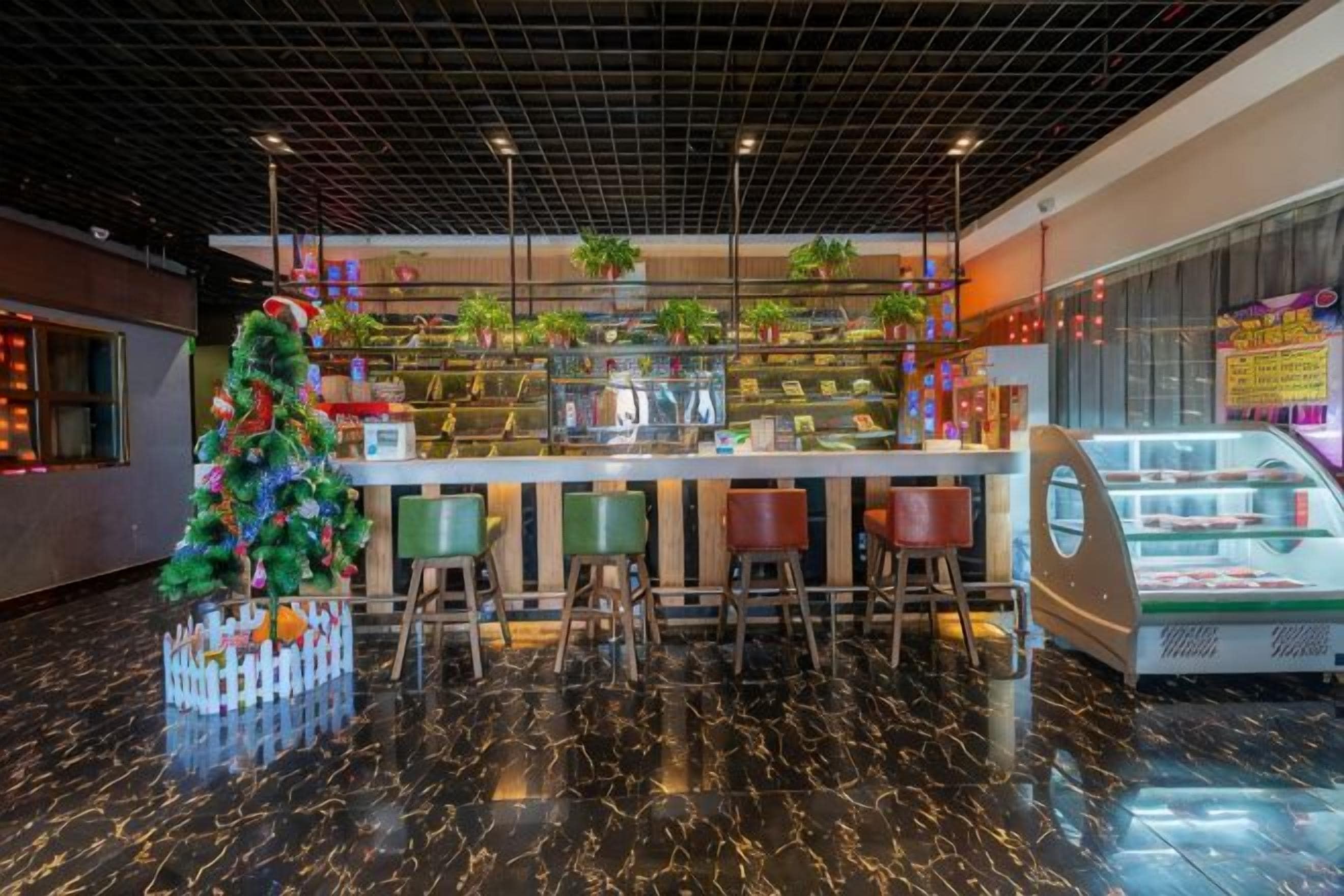 Zona de bar con un árbol de Navidad, asientos y una vitrina.