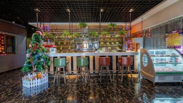 Zona de bar con un árbol de Navidad, asientos y una vitrina.