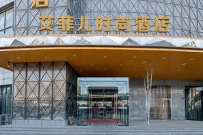 A hotel entrance with a modern design, featuring a geometric facade and a prominent entrance canopy. - Aifeier Shishang Hotel (Zhengzhou)