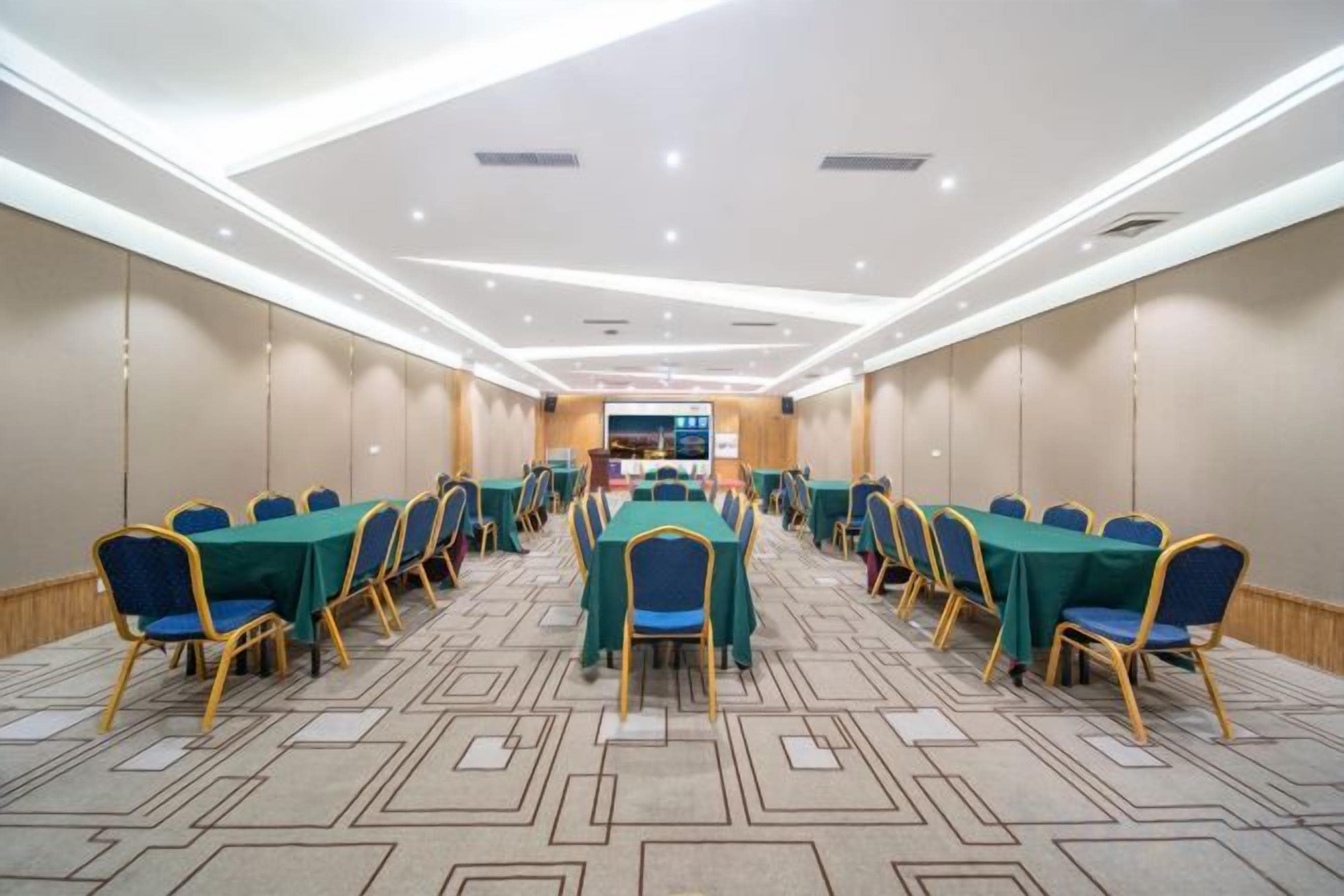 Una sala de conferencias con mesas y sillas dispuestas para reuniones.