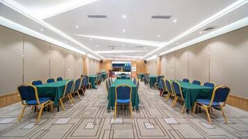 Una sala de conferencias con mesas y sillas dispuestas para reuniones.
