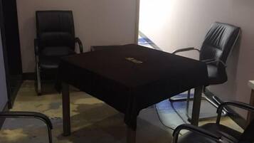 Un salón de conferencias con una mesa y cuatro sillas.