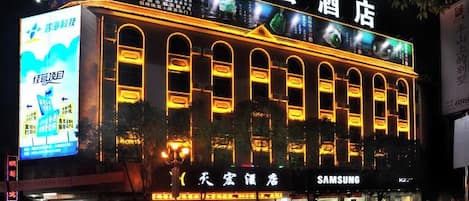 A hotel with illuminated signage and multiple entry points.