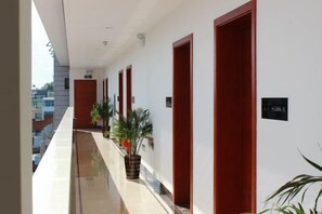 A hotel corridor with doors, potted plants, and a sign indicating room number 306. - Ruili Tianhong Hotel (Ruili)