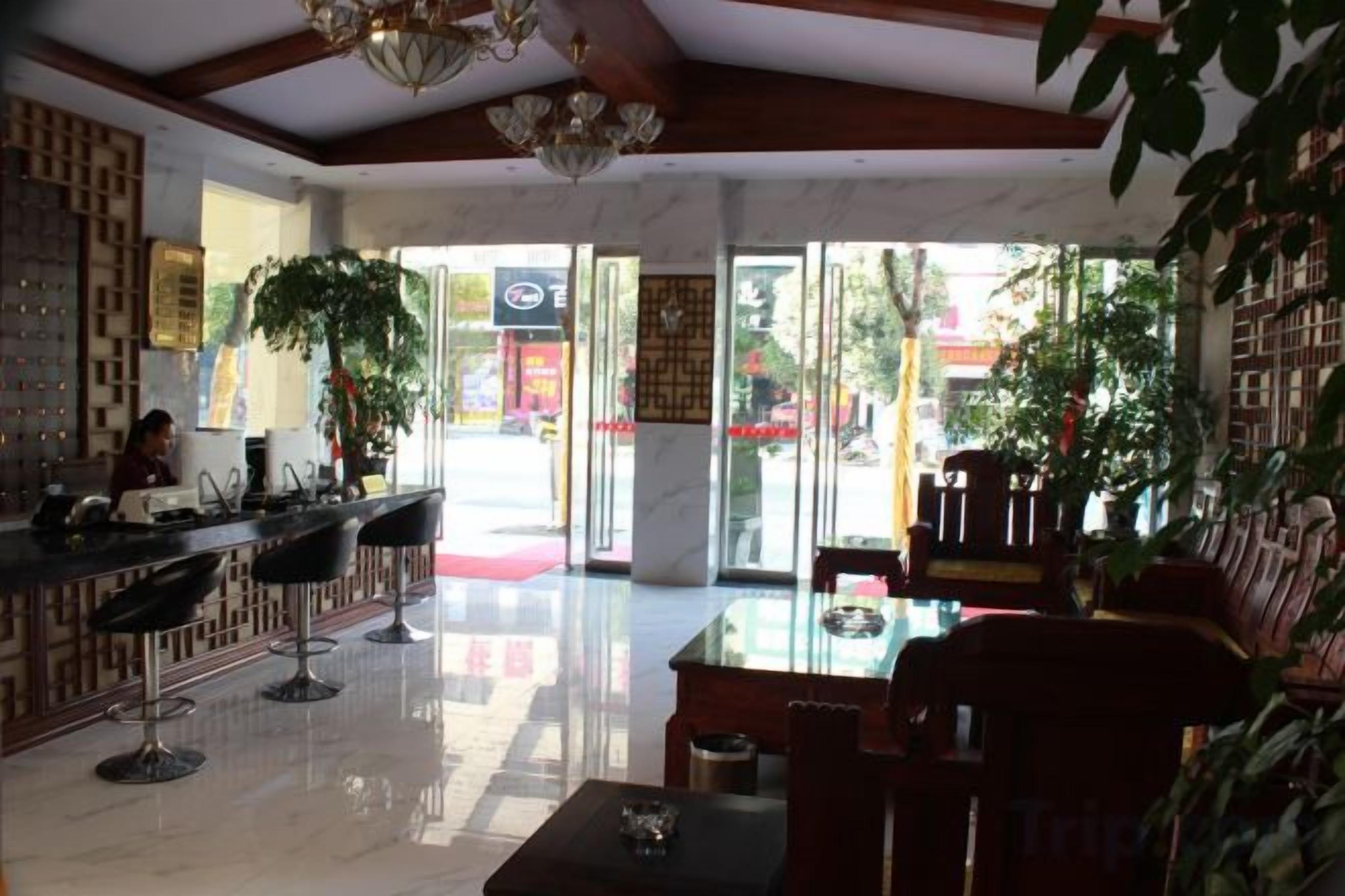 Un vestíbulo de hotel con mostrador de recepción, zona de estar y amplios ventanales que dejan entrar luz natural.