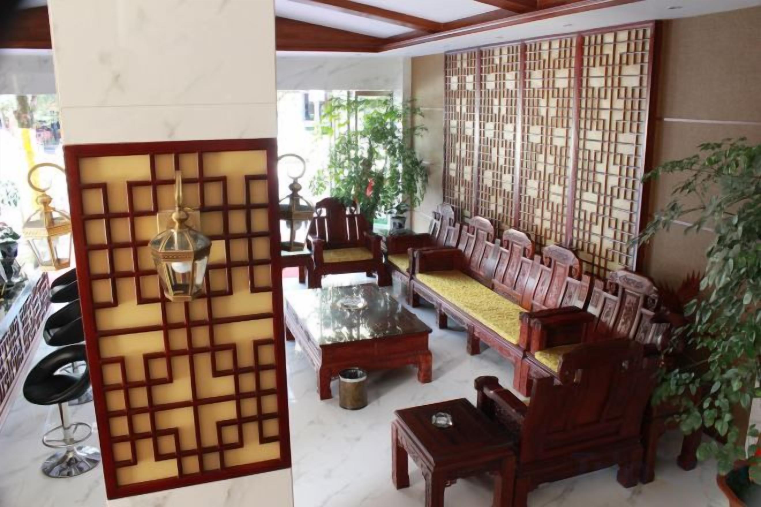 Una sala de estar de estilo tradicional con un conjunto de sofás, una mesa de centro y un biombo decorativo.