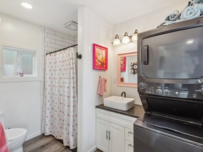 Bathroom features a shower, sink, and washing machine.