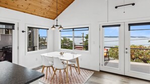 Una cocina moderna con comedor, ventanas amplias y vista al agua.