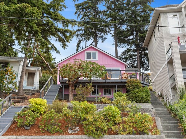 Stunning two-story home with a balcony and lush green surroundings.