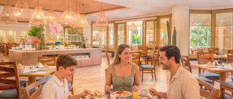 A breakfast setting with wooden furniture, a buffet with various food items, and hanging pendant lights.