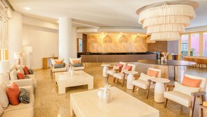 A spacious lobby with a reception desk, seating area, and a large chandelier. - GR Solaris Lighthouse Los Cabos (San José del Cabo)