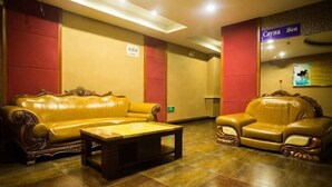 A lobby with a yellow leather sofa, a matching armchair, and a small table. - Jixibeifu Hotel (Jixi)