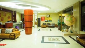 A lobby with a reception desk, a large wooden column, a globe, and a sofa. - Jixibeifu Hotel (Jixi)