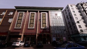 A building with vertical decorative panels and a glass facade. - Jixibeifu Hotel (Jixi)