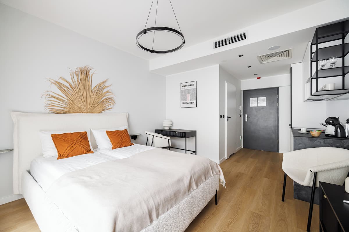 Un dormitorio moderno con una cama grande, un escritorio y una silla.