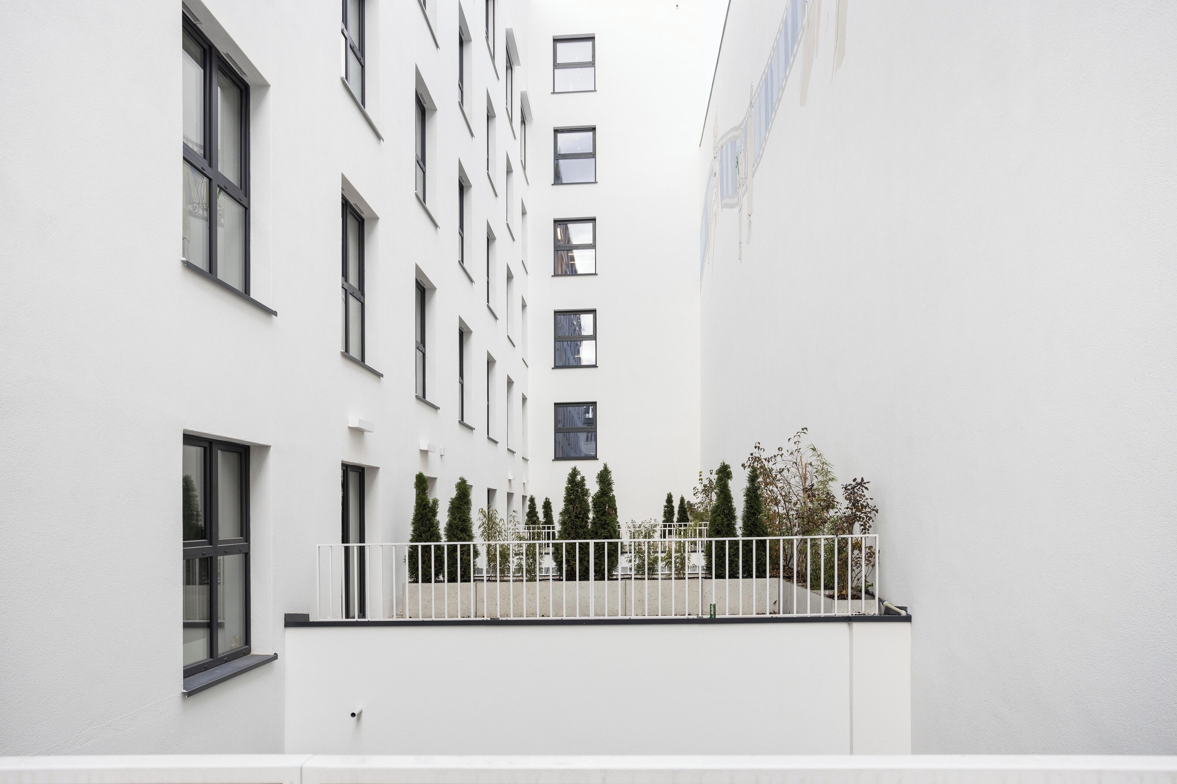 A modern building with multiple windows and a white exterior.