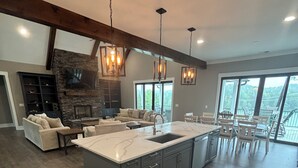 A spacious kitchen with a large island, wooden flooring, and pendant lighting. - Brand new luxury craftsman. 5000 sqft with 5 bedrooms, 5 baths and bunk room. (Six Mile)