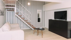 A modern living room with a staircase, a sofa, a TV, and a black cabinet. - Maison Work & Travel 2 - Palermo  (Buenos Aires)
