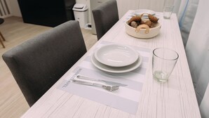 A dining table set with plates, cutlery, and a glass, with a placemat displaying "MORGENSTERN" and a basket of pinecones. - Maison Work & Travel 2 - Palermo  (Buenos Aires)