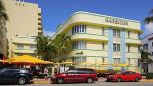 Un hotel con fachada curva, detalles en amarillo y verde, y un letrero que dice "BARBIZON".