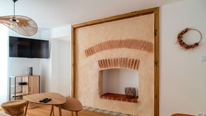Un salon moderne avec une cheminée, un téléviseur et un meuble en bois.