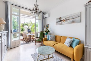 A living room with a yellow sofa, a glass coffee table, and a dining area with a table and chairs. - Happyfew La Promenade 53 (Nice)