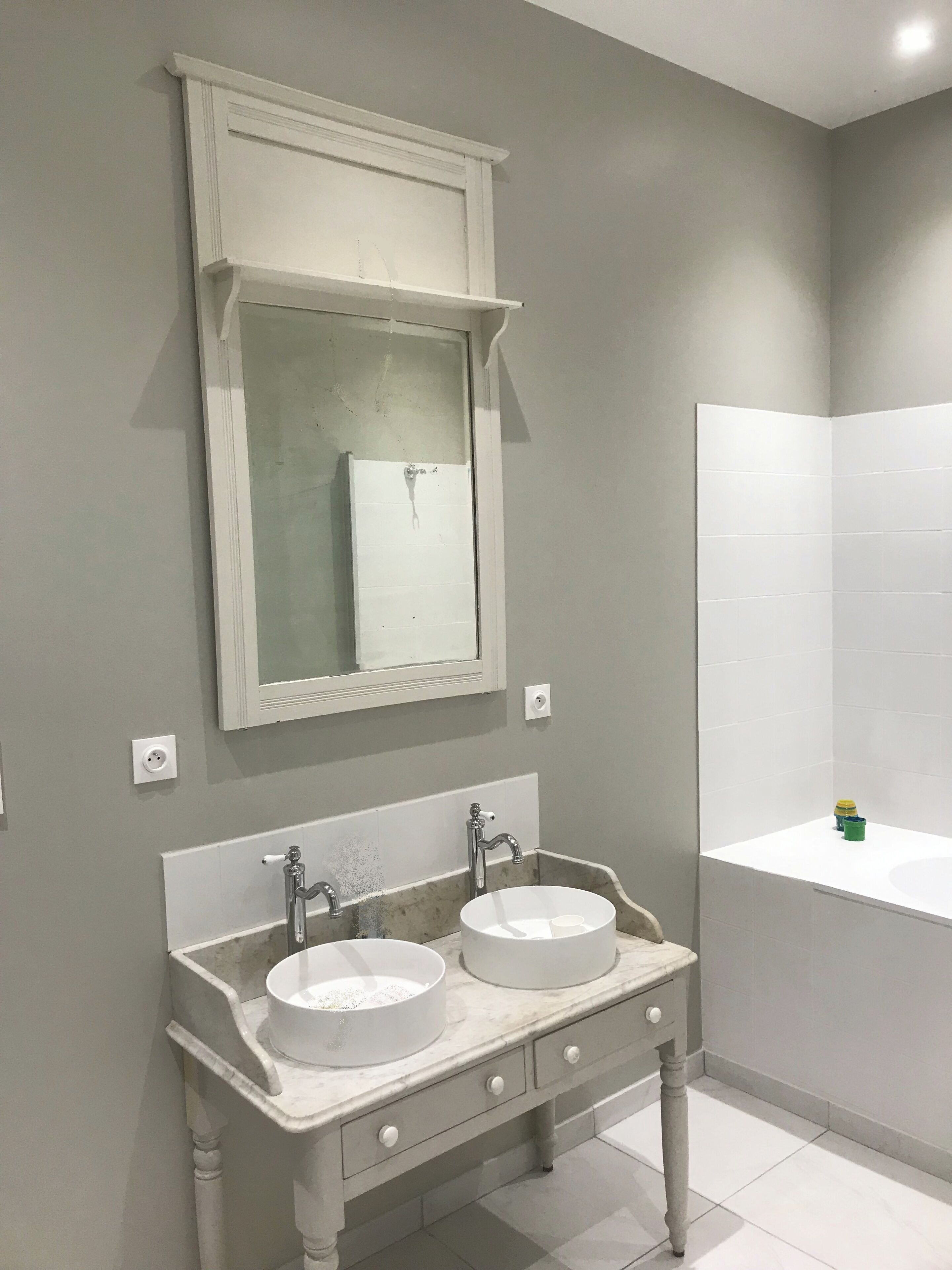 A bathroom with two sinks, a mirror, and a bathtub.