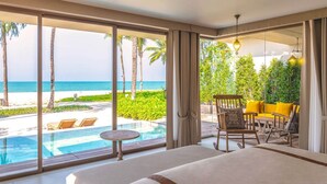 Un dormitorio con un ventanal grande con vistas a una piscina y una playa.