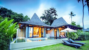 A modern villa with a glass infinity pool, two bedrooms with large windows, and a private outdoor lounge area with sun loungers and an umbrella. - The Vijitt Resort - Vijitt Pool Villa (Rawai)