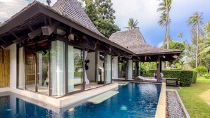 A modern poolside area with a glass-enclosed structure, a clear pool, and a well-maintained garden. - The Vijitt Resort - Vijitt Pool Villa (Rawai)