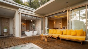 Ein modernes Spa mit Holzterrasse, Whirlpool und gelber Couch.