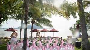 A wedding setup with chairs and tables arranged outdoors, overlooking a body of water.