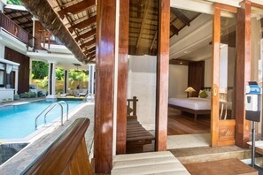 A hotel room with a pool, wooden furniture, and a bed. - Harlan Beach Villa Boracay (Boracay Island)