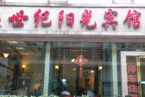A building with a sign in Chinese characters, a glass entrance, and a visible interior with a chandelier.