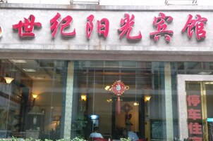 Un edificio con un letrero en caracteres chinos, una entrada de vidrio y un interior visible con un candelabro.