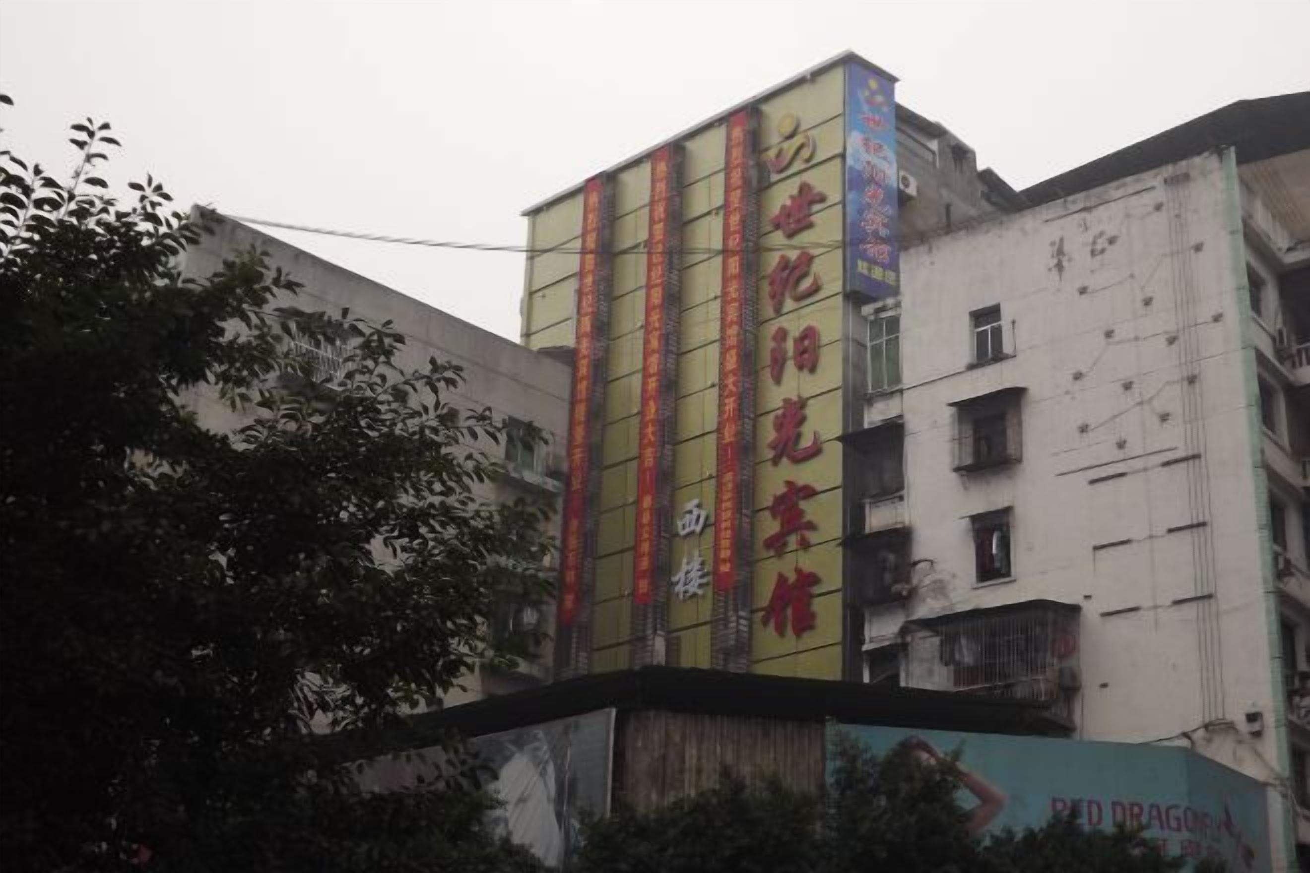 A multi-story building with vertical signage and a large advertisement on the lower level.