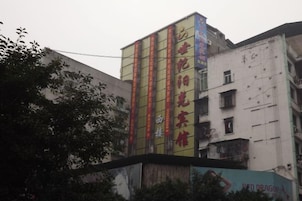 Un edificio de varios pisos con señalización vertical y un anuncio grande en la planta baja.