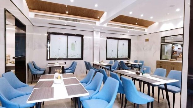 A modern conference room with blue chairs and tables, large windows, and a wooden ceiling. - Quxian Century Sunshine Hotel-The West Hotel (Qu County)