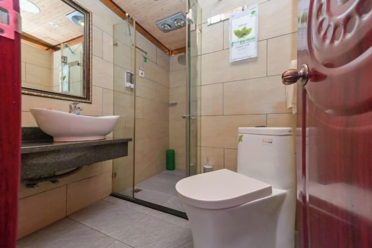 A bathroom with a sink, toilet, and glass shower enclosure.