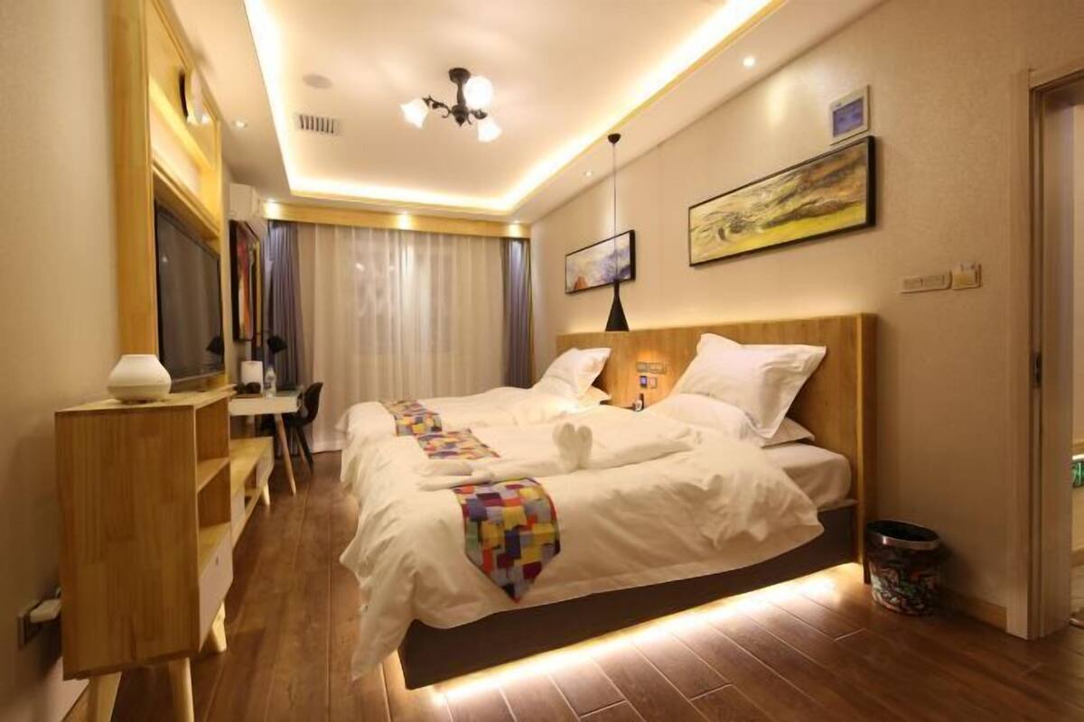 Ein Hotelzimmer mit Bett, Schreibtisch, Stuhl und einem Bild an der Wand.