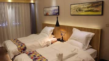 Una habitación de hotel con dos camas, una mesita de noche, una lámpara y obras de arte en las paredes.